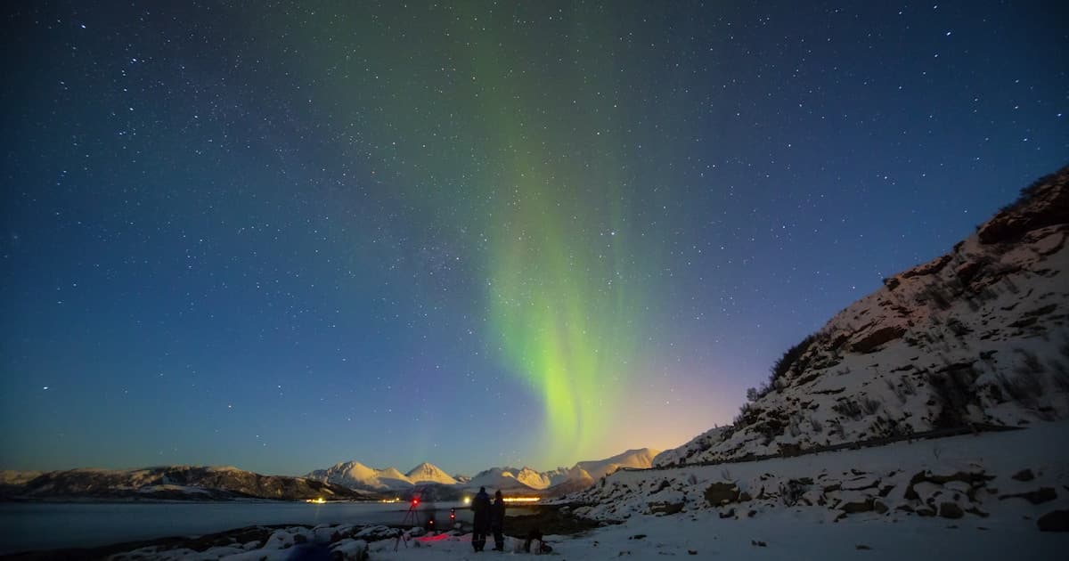 Travelers watching aurora borealis in northern Norway